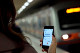 mobile ticketing with metro train in background